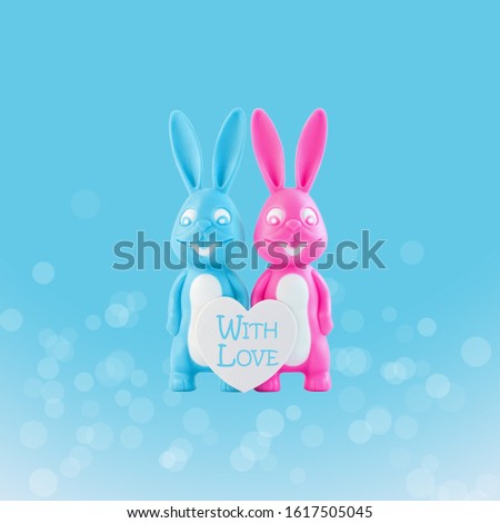 Valentine's day card, cute bunnies happy lovers couple with white heart on blue bokeh background. Family love and dating concept.Easter banner. Pink and blue rabbits.Creative minimal style,copy space
