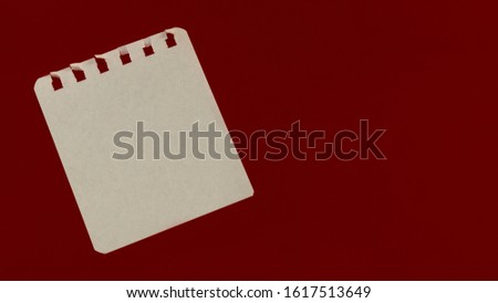 Torn notepad sheet on a burgundy background. Minimalist theme.