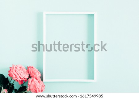 Beautiful flowers composition. Blank frame for text, pink rose flowers on pastel blue background. Valentines Day, Easter, Birthday, Happy Women's Day, Mother's day. Flat lay, top view, copy space