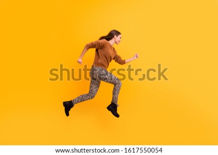 Full body profile photo of pretty funky lady jump high speed rushing black friday shopping wear casual fluffy sweater leopard trousers boots isolated yellow color background