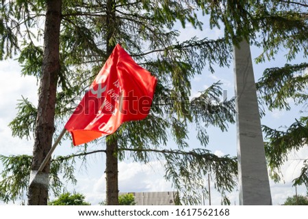 The red flag of the Soviet Union in the wind against the background of trees
