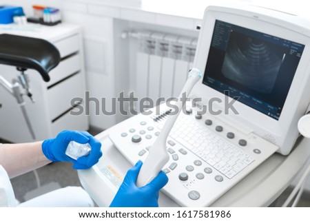 gynecologist doctor prepares an ultrasound machine for the diagnosis of the patient. Applies gel to a transvaginal ultrasound scanner. Women Health Concept. Royalty-Free Stock Photo #1617581986