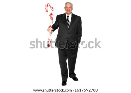 Christmas. A business man holds a Giant Red and White Candy Cane. Isolated on white. Room for text. Clipping Path. People world wide celebrate Christmas each year. Candy Canes are a part of Christmas.