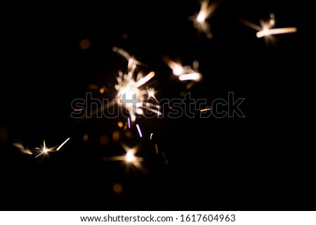 Bright sparklers burn on a black background. Flashes of fire. Decorative element for Christmas, New Year and birthday designs.