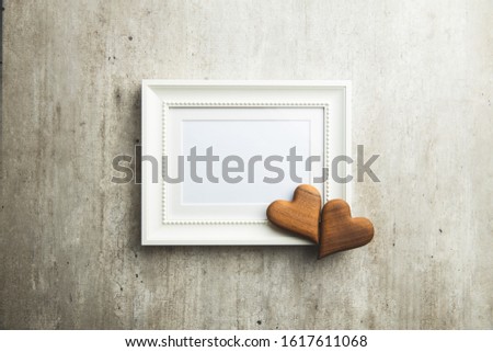 Love Valentine's Day concept. Blank picture frame and wooden heart. Top view.