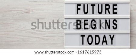 'Future begins today' words on a modern board on a white wooden background, top view. Overhead, from above, flat lay. Space for text.