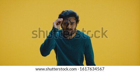 Medium shot of young man fixing his glass and concentrating Royalty-Free Stock Photo #1617634567