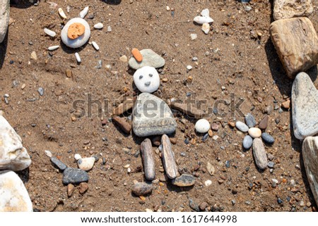 Touching рicture of sea pebbles on the shore. Child plays ball. An image of a child playing a ball made of stones
