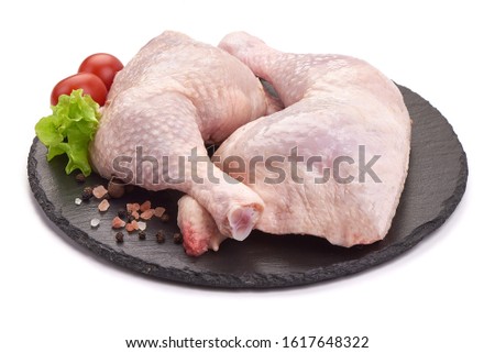 Raw chicken leg quarters on a stone plate, isolated on white background. Royalty-Free Stock Photo #1617648322