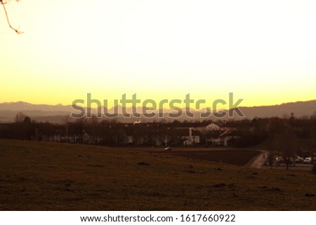 panoramic picture of the alps with a small town called weilheim in the foreground
