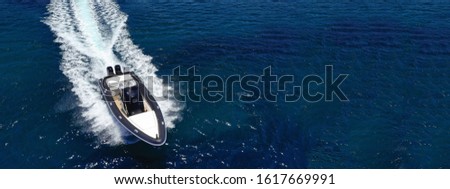 Aerial drone ultra wide photo of inflatable rigid power boat cruising in high speed in Mediterranean deep blue sea bay