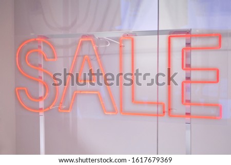 Neon red sign sale on storefront. Close up.