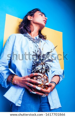 lifestyle people concept. young pretty smiling indian girl with long nails wearing lot of jewelry rings holding pineapple, asian summer happy cool