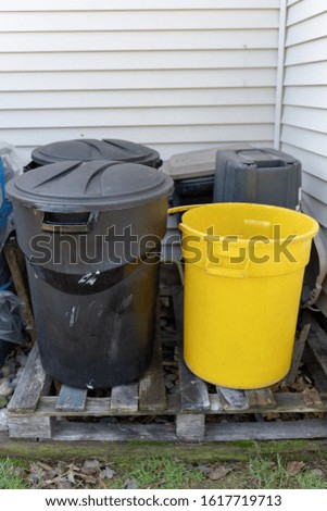 Trash and recycling cans sit on a pallet Royalty-Free Stock Photo #1617719713