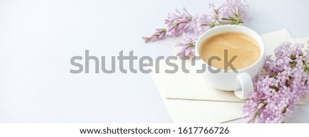 Minimal elegant composition with coffee cup and lilac branches, envelope on white background, female morning breakfast, woman mother day, saint valentine day, wedding, banner