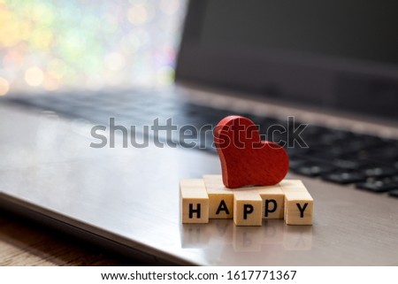 Red heart and wooden words HAPPY on computer keyboard soft bokeh. Internet dating, Valentines day concept.