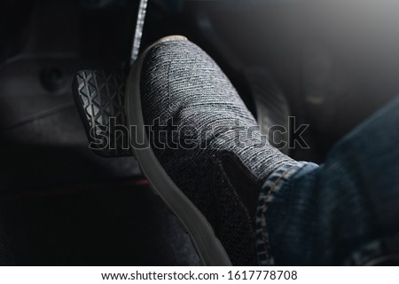 Close up the foot pressing brake pedal of a car. Driver stopping the car. Royalty-Free Stock Photo #1617778708