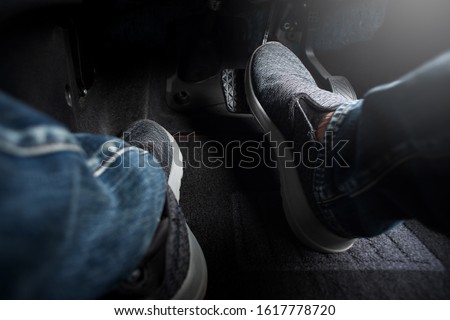 Close up the foot pressing brake pedal of a car. Driver stopping the car. Royalty-Free Stock Photo #1617778720