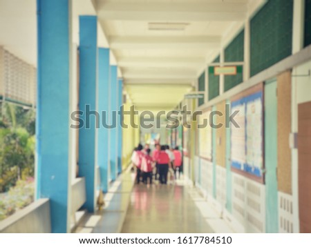 Blurred image, many students are walking on the school building.