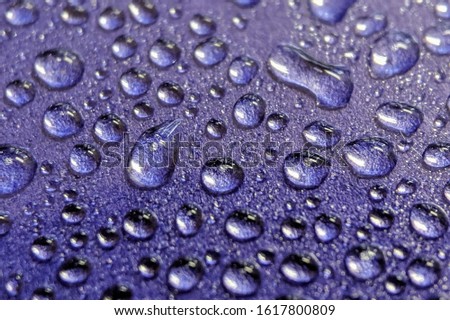Water droplets on purple background. Selective focus.