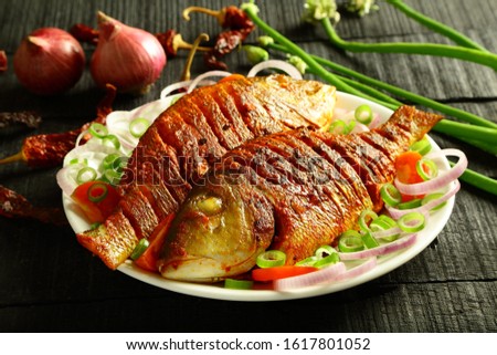 Crispy baked fish with exotic herbs and spices  Royalty-Free Stock Photo #1617801052