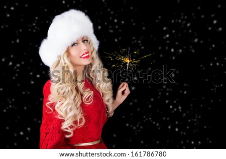 happy beautiful woman in fur hat and red dress with bengal light in hand