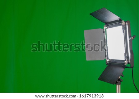 Front view of a bright shining video light in front of a green screen