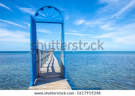 A blue door on the beach of Sandy Bay on the Roatan Island of the Caribbean Sea. Honduras