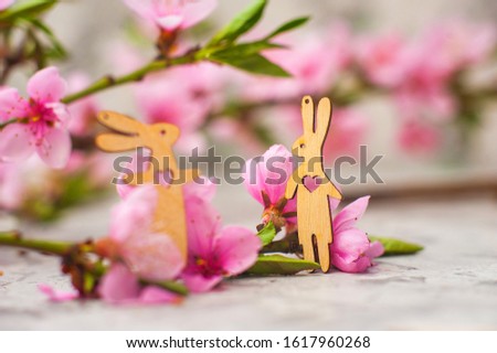 Spring photo of a blossoming tree and bunnies close-up and copy space. Easter card concept with hares and flowers. Trending pink shades.