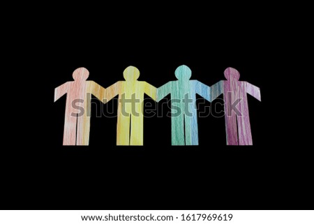 Rainbow paper cut into pictures of people holding hands isolated on black background - to communicate with people to stop racism, gender and create peace with each other.