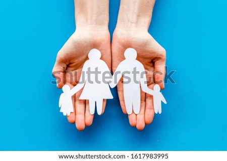 Live insurance concept. Family silhouette on palms on blue background top-down