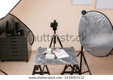 Tasty macarons with glass of milk on table in professional photo studio
