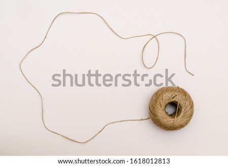 Hemp cord, jute twine on white paper backgound. Texture of the brown natural rustic hemp cord in roll on white paper texture background
