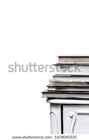 Stack of books on an old chest of drawers on a white background