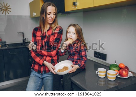 Cute little girl with mother. Family at home in a kitchen