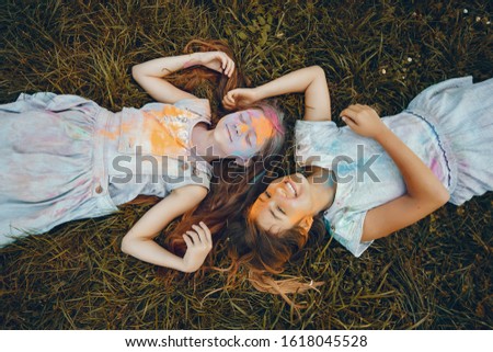 Beautiful girls with a colorful dry paints. Friends have fun in a summer park