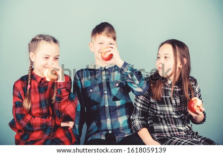 Group cheerful teenagers having fun and eating apples. Teens with healthy snack. Healthy dieting and vitamin nutrition. Boy and girls friends eat apple snack while relaxing. School snack concept.