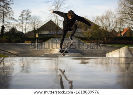 handsome young adult skater jumping high with a trick ollie