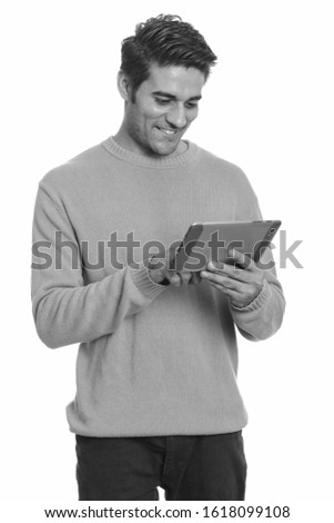 Young happy Persian man using digital tablet