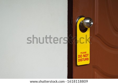 Closed door with please do not disturb sign on handle of hotel room