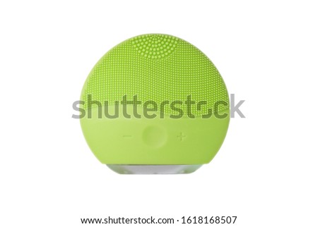 Light green silicone face cleansing brush isolated on white. Brushes for skin treatments. Cosmetic procedure. First step, skin cleaning. Peeling and gently rubbing face. Copy space, design space.