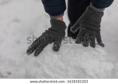 Men's hands make a snowball for a snowman. Sculpt from the snow, leisure, winter, the game of snowballs.