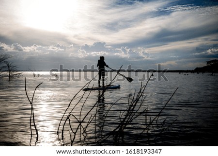 
silhouette of a woman rowing on a board.