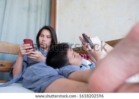  chinese child playing smartphone with mother, play phone, watching cartoon, family
