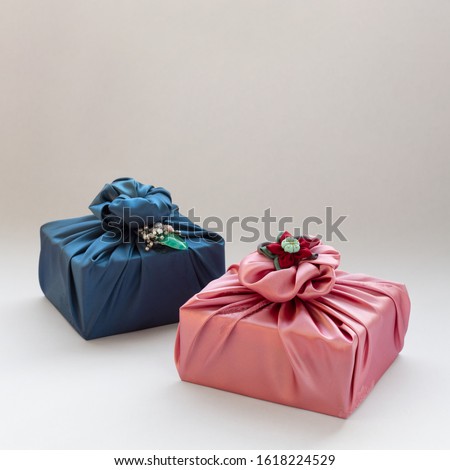 Korean traditional gift packaging cloth made of silk(bojagi) and ornaments with copy space. Isolated on white background. Royalty-Free Stock Photo #1618224529