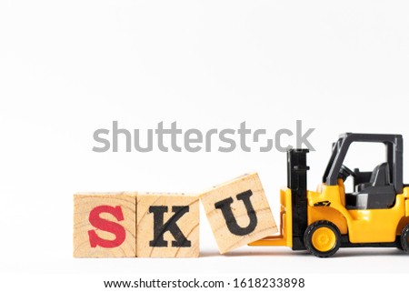 Toy forklift hold wood letter block U to complete word SKU (abbreviation of stock keeping unit) on white background