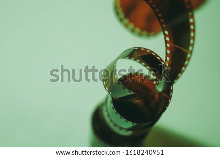 35 mm film tape on turquoise background. Film photography concept. Film development. Creative hobby. Film photo amateur