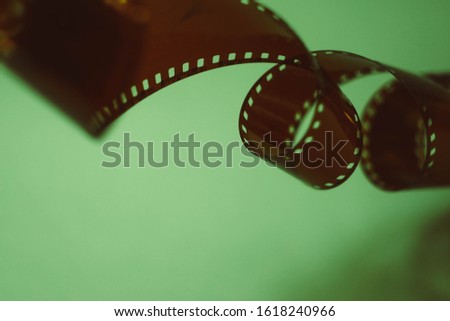 35 mm film tape on turquoise background. Film photography concept. Film development. Creative hobby. Film photo amateur