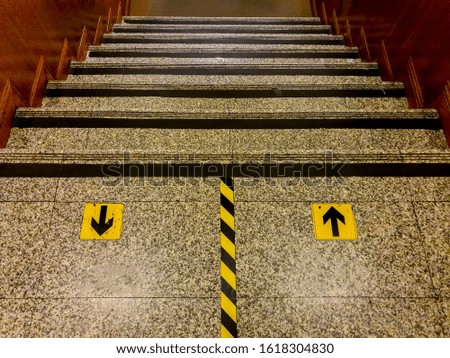 Granite floor with arrow up and down on  staircase.