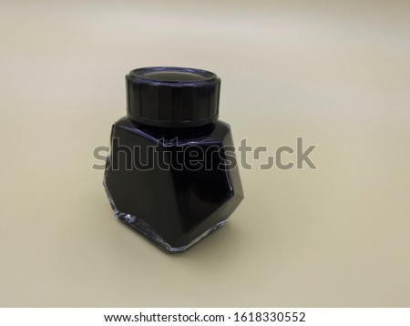 
Black fountain pen ink in a little container. Cream color background. Unbranded ink. Hand lettering ink.